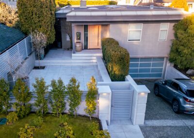 Modern granite hardscape installation with large-format pavers, stair treads, and privacy wall at a residential property in Victoria, BC.