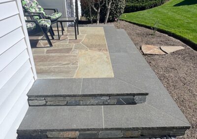 Custom natural stone porch with multi-tone flagstone and stacked stone steps in Victoria, BC.