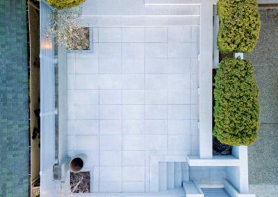 Modern granite hardscape installation with large-format pavers, stair treads, and privacy wall at a residential property in Victoria, BC.