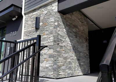 Exterior view of natural stone veneer installation using Ocean Mist stone from K2 Stone at a mixed-use development on 713 St. Patrick Street in Oak Bay