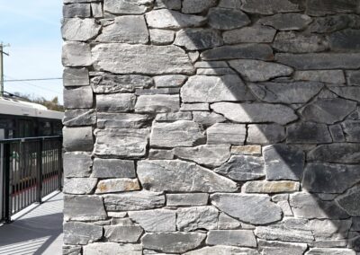 Exterior view of natural stone veneer installation using Ocean Mist stone from K2 Stone at a mixed-use development on 713 St. Patrick Street in Oak Bay