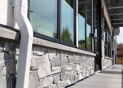 Exterior view of natural stone veneer installation using Ocean Mist stone from K2 Stone at a mixed-use development on 713 St. Patrick Street in Oak Bay