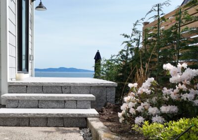 Granite stone steps built with natural granite treads at a coastal residential property, showcasing precision stone installation and ocean view landscaping.