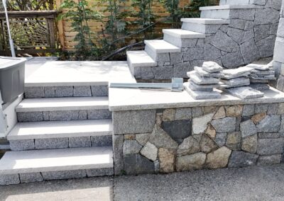 Granite stone steps built with natural granite treads at a coastal residential property, showcasing precision stone installation and ocean view landscaping.
