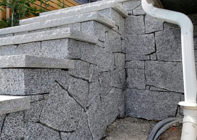 Granite stone steps built with natural granite treads at a coastal residential property, showcasing precision stone installation and ocean view landscaping.
