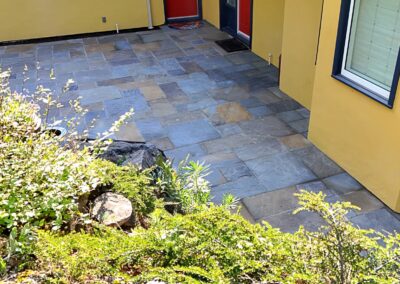 Bluestone patio installation around a residential home in Greater Victoria BC completed by Orca Masonry