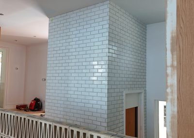 Interior brick installation around elevator enclosure in Victoria custom home by Orca Masonry
