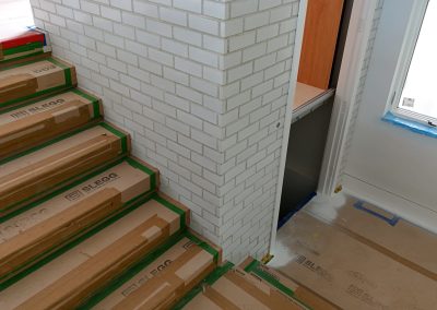 Interior brick installation around elevator enclosure in Victoria custom home by Orca Masonry
