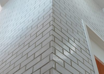 Interior brick installation around elevator enclosure in Victoria custom home by Orca Masonry