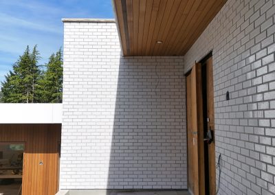 Exterior white brick façade on modern custom home in Victoria by Orca Masonry