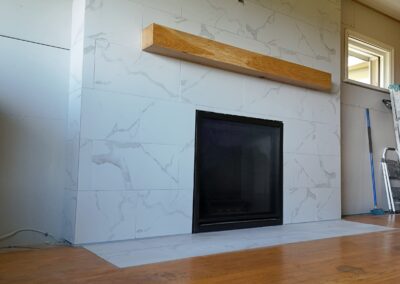 Modern fireplace installation with Carrara porcelain tile by Orca Masonry in Victoria BC
