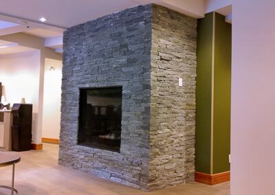 Stone fireplace installation at Fairways Hotel by Orca Masonry using natural K2 Stone veneer.
