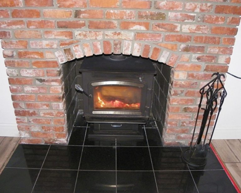 Red brick fireplace with a black tile hearth