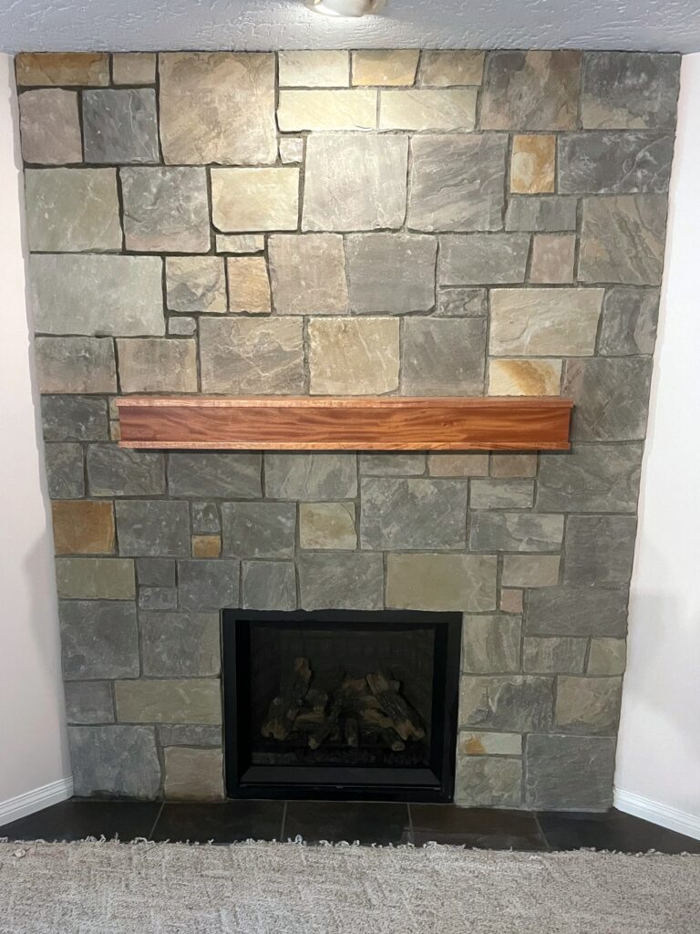 Natural stone fireplace with a modern wood mantel