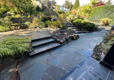 Handcrafted natural stone steps leading through a landscaped garden in Victoria, BC.
