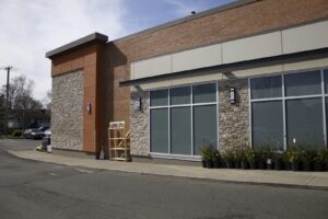 Commercial building exterior with manufactured stone veneer, brick, and modern architectural paneling.