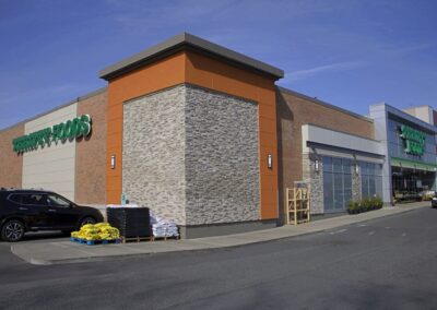 Commercial building exterior with manufactured stone veneer, brick, and modern architectural paneling.