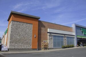 Commercial building exterior with manufactured stone veneer, brick, and modern architectural paneling.