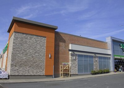 Commercial building exterior with manufactured stone veneer, brick, and modern architectural paneling.