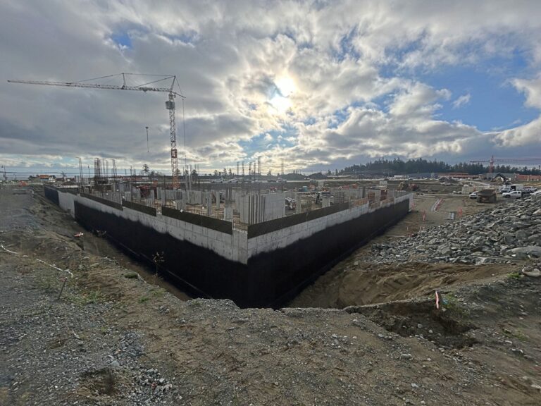 Waterproofed foundation walls in a deep excavation under a cloudy sky