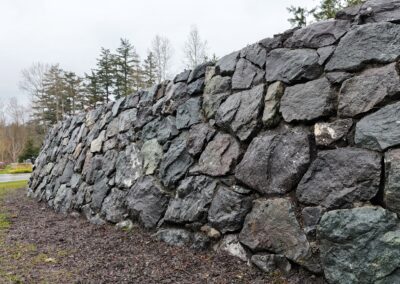Natural stone retaining wall in Victoria, BC, built for erosion control and landscaping.