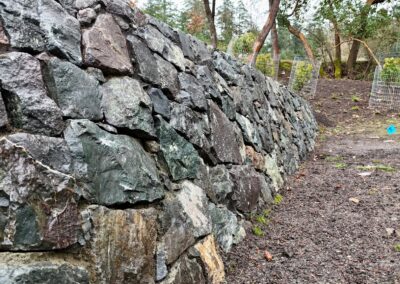 Natural stone retaining wall in Victoria, BC, built for erosion control and landscaping.