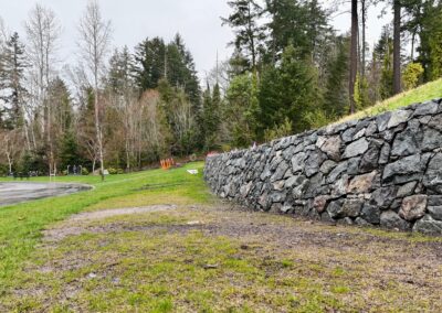 Natural stone retaining wall in Victoria, BC, built for erosion control and landscaping.