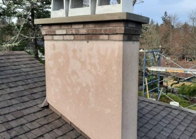 New Brick Installation Over Stucco Chimney With Concrete Crown