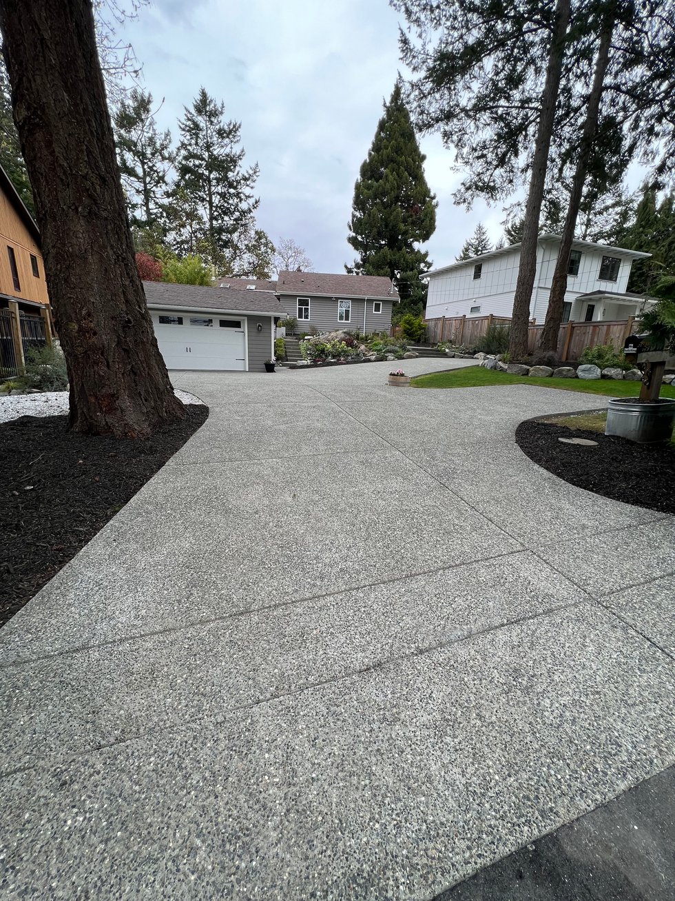 Exposed aggregate concrete driveway leading to a garage