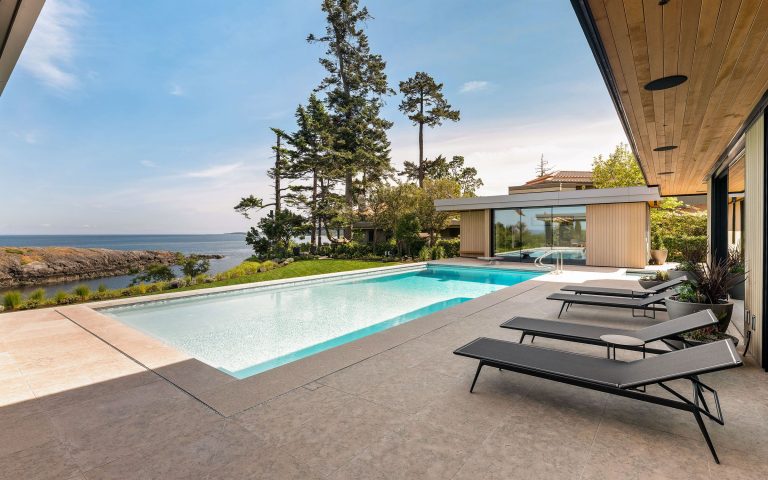 Oceanfront pool with a wide stone deck and loungers