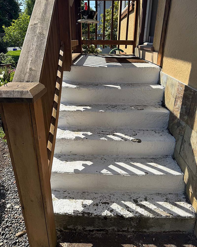 Concrete stairs to a deck with a flaking painted coating, before StepClad