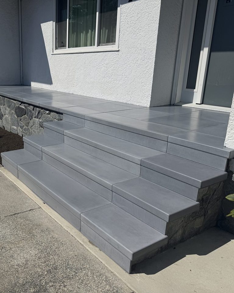 Wide grey StepClad treads, a tiled landing and stone veneer on the sides