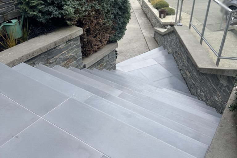 A long run of light grey StepClad steps and landing tiles between stone walls