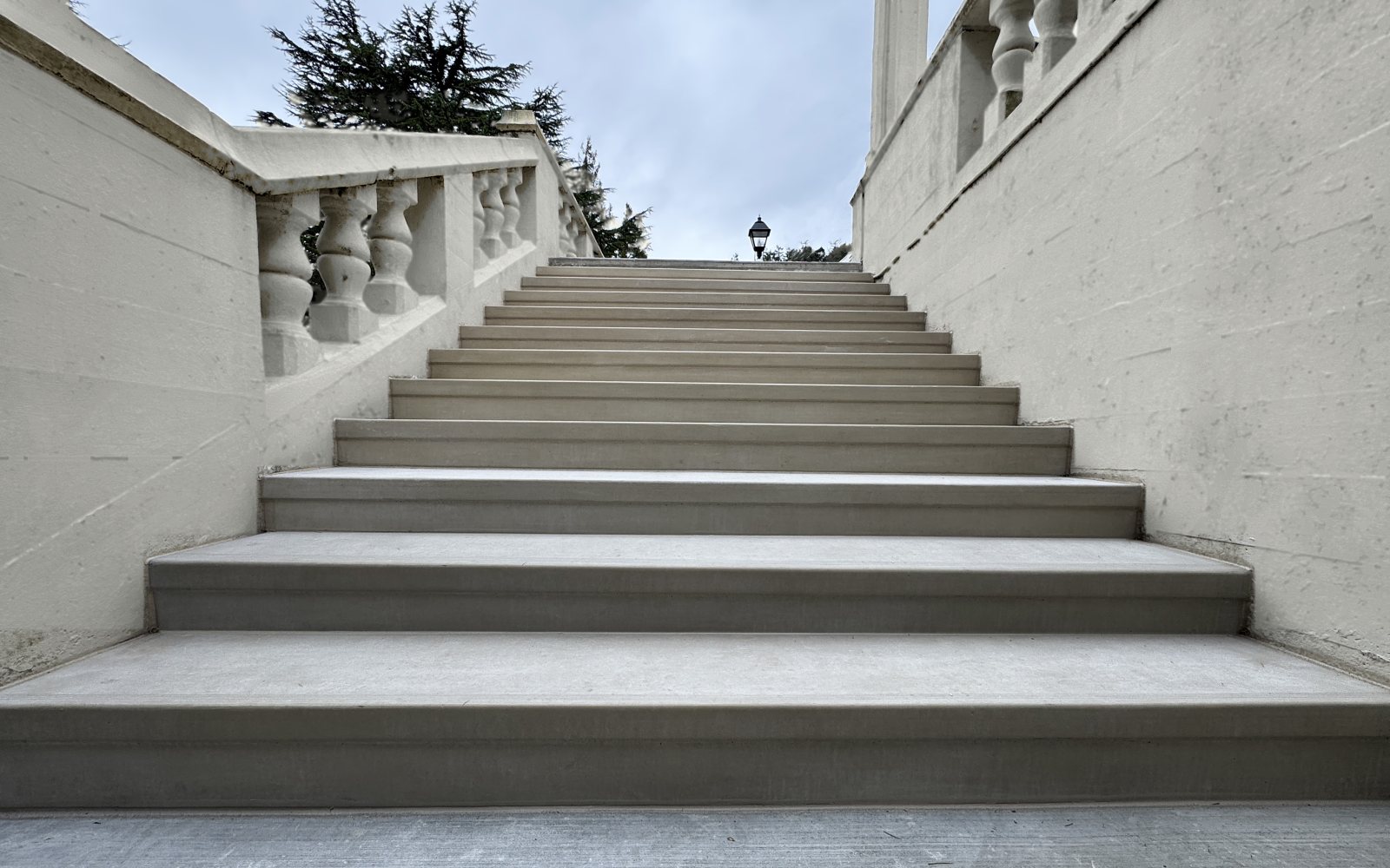 A long flight of finished StepClad treads rising between cream balustrade walls
