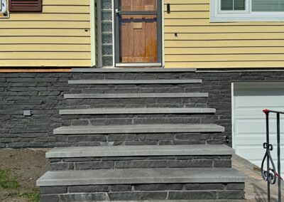 Custom stone steps with dark grey cladding installed on a residential entrance in Victoria, BC.